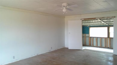 Unfurnished room featuring ceiling fan and hardwoo