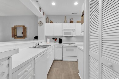 Kitchen featuring sink, white appliances, white ca