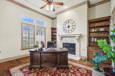Home office with a tiled fireplace, ceiling fan, d
