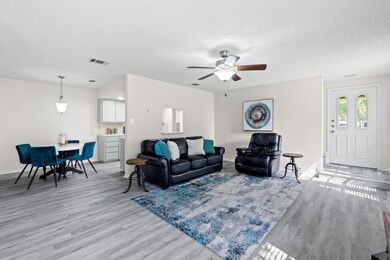 Living area with a textured ceiling, light wood-t