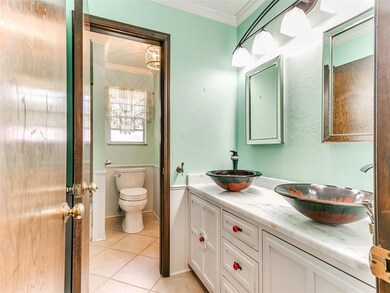 Bathroom with crown molding, toilet, tile patterne