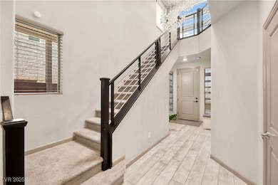 Staircase with wood finished floors and a towering