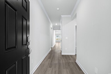 Hall featuring ornamental molding and light hardwo