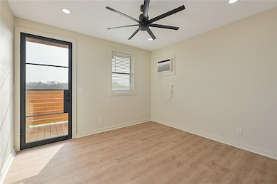 Unfurnished room featuring light wood-style flooring, recessed lighting, ceiling fan, and a wall mounted AC
