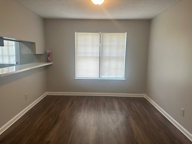 Unfurnished room featuring dark wood-type flooring and a textured ceiling