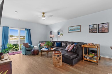Living area featuring a ceiling fan, wood finished floors, and baseboards