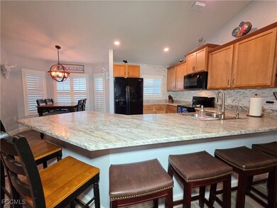 Kitchen featuring black appliances, a peninsula, b