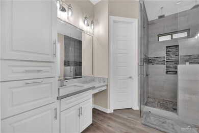 Full bathroom featuring a shower stall, baseboards, wood finished floors, and vanity