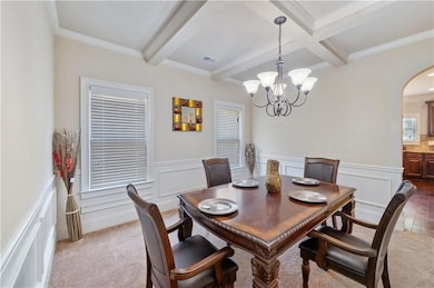 Dining area featuring arched walkways, beam ceilin