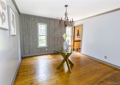 Hardwood floored spare room featuring a chandelier