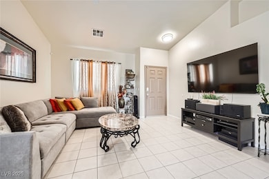Living area featuring vaulted ceiling, light tile