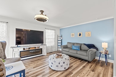 Living room with baseboards, crown molding, and li