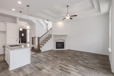 Kitchen featuring a sink, a raised ceiling, wood 