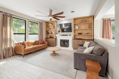 Living area with ceiling fan and a fireplace with