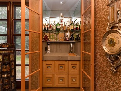 Wet bar with shagreen textured limestone counter and secret drawer
