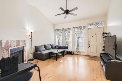 Living area with a ceiling fan, a tile fireplace,