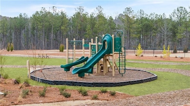 Community play area with a forest view and a yard