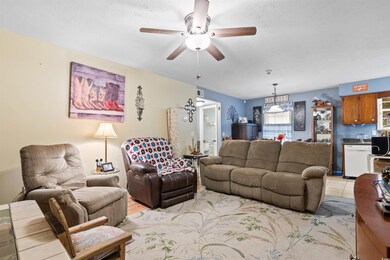 Living room with a textured ceiling and ceiling fa