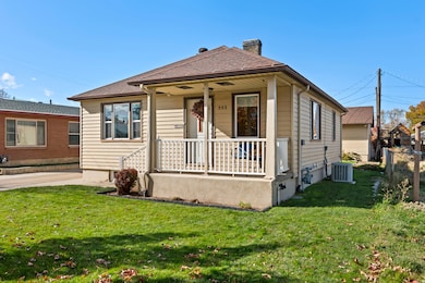 View of front of house featuring a porch, a front lawn, and a chimney