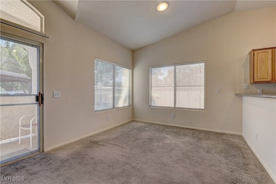 Unfurnished dining area with lofted ceiling and light carpet