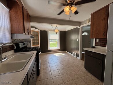 Kitchen with sink, decorative light fixtures, appliances with stainless steel finishes, ceiling fan, and light tile patterned floors