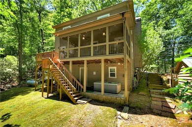Back of property with a hot tub, a screened in porch, stairs, a wooden deck, and a lawn