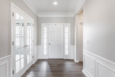 Expansive Foyer with brand new Luxury Vinyl Plank flooring, French doors to Study and Panel Moulding - all custom details to greet you