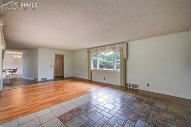 Empty room featuring a chandelier, a textured ceiling, wood finished floors, and baseboards