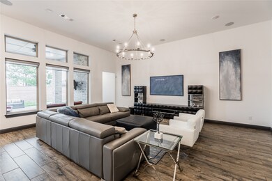 This living room is more like a GREAT room featuring custom paint, recessed lighting, custom light fixture, and an amazing wall of windows providing a lovely view of your backyard to keep an eye out on the kids or pets playing.