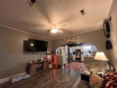 Living room featuring ceiling fan, ornamental molding, and hardwood / wood-style floors