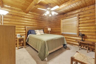 Bedroom featuring a wood ceiling with exposed bea