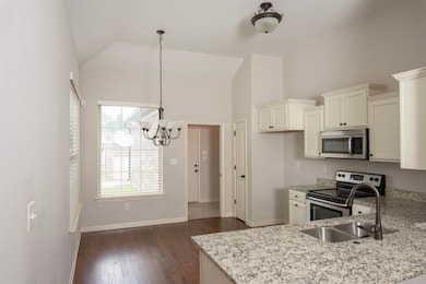 Kitchen with white cabinets, dark hardwood / wood-