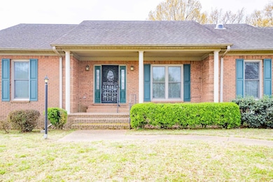 Doorway to property featuring a yard, brick siding