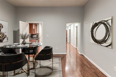 The dining area leads to the kitchen, which is beyond, and the foyer provides access to the entry, guest bedroom and bath. This photo is virtually staged.