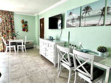 Living area featuring crown molding and light tile patterned flooring