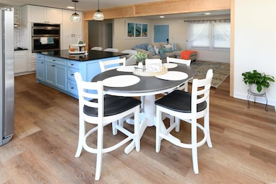 Dining area with light wood finished floors, baseboards, and recessed lighting