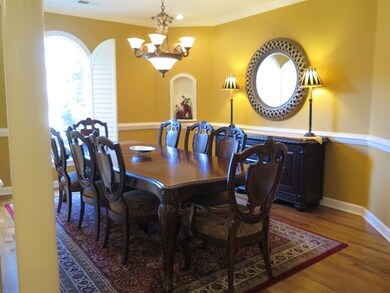 Large Entry with Hardwood and Columns Opens to Din