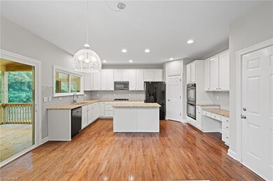 The kitchen is open to the great room and is updated with painted white cabinets and backsplash.
