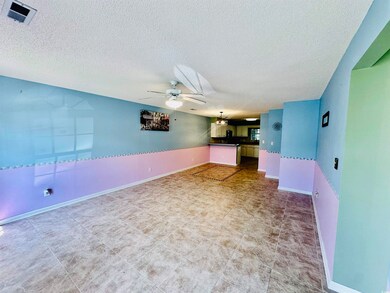 Unfurnished living room featuring a textured ceiling and ceiling fan