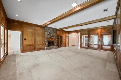 Unfurnished living room featuring wood walls, ligh
