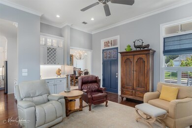 Living room with ceiling fan with notable chandeli
