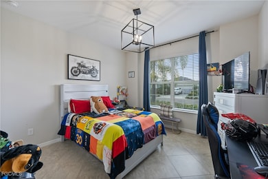 Tiled bedroom featuring a chandelier