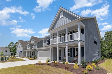 View of front facade with concrete driveway, a porch, a front yard, a residential view, and an attached garage