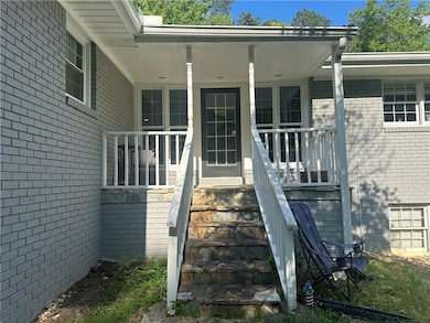 Property entrance with brick siding and covered po
