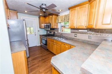 Updated kitchen with hard floors leads to the covered back deck.