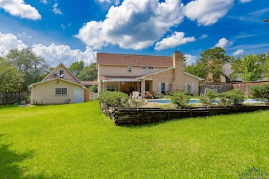 Rear view of house with a fenced backyard, brick siding, and a chimney