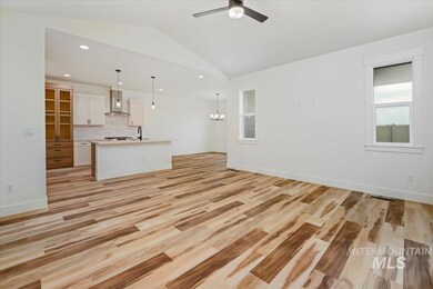 Unfurnished living room with lofted ceiling, ceiling fan, light wood finished floors, recessed lighting, and a chandelier