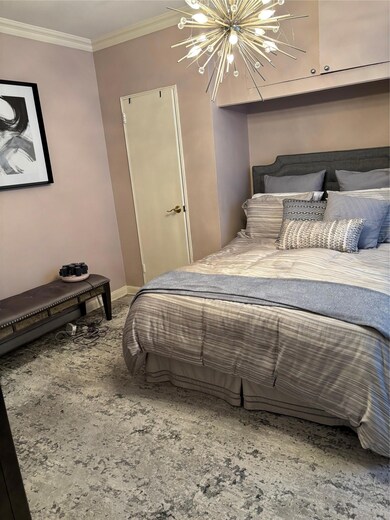 Bedroom with a chandelier and ornamental molding