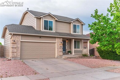 View of front of house featuring a garage and a po