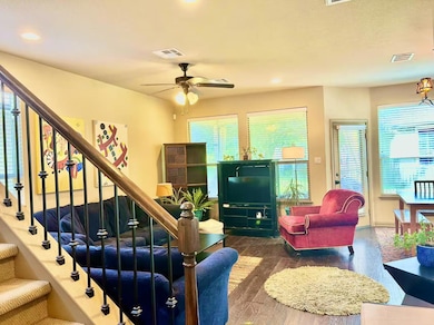 Living room featuring a ceiling fan, stairway, wo